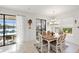 Dining room features stylish light fixture, a decorative cuckoo clock, and access to the outdoor pool and kitchen area at 10819 Wicker Park Pl, Palmetto, FL 34221