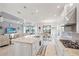 Open concept kitchen and living room with white cabinets, granite countertops, stainless steel appliances, and marble floors at 10819 Wicker Park Pl, Palmetto, FL 34221