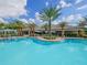 Large community pool with palm trees, cabanas, and lounge seating at 10819 Wicker Park Pl, Palmetto, FL 34221