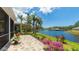 Paver patio with manicured landscaping and a tranquil lake view at 11116 Sanctuary Dr, Bradenton, FL 34209