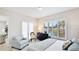 Relaxing bedroom features a comfortable armchair and view of the lake through plantation shutters at 11116 Sanctuary Dr, Bradenton, FL 34209