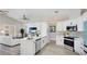 Open-concept kitchen with island, white cabinets, stainless appliances, and view into living area at 11116 Sanctuary Dr, Bradenton, FL 34209