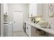 Well-appointed laundry room features modern appliances, white cabinetry and tile floors at 11116 Sanctuary Dr, Bradenton, FL 34209