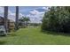 Spacious backyard with lush greenery, a view of the lake and a tree line in the distance at 11592 57Th Street E Cir, Parrish, FL 34219