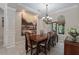 Elegant dining room with a large painting, chandelier, decorative molding, and an adjacent window at 11592 57Th Street E Cir, Parrish, FL 34219