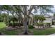 Inviting single-story house showcases manicured lawn, mature trees, and a welcoming front entrance with landscaping at 11592 57Th Street E Cir, Parrish, FL 34219