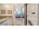 Bright bathroom leading to the main bedroom with a stacked washer and dryer at 1212 Benjamin Franklin Dr # 503, Sarasota, FL 34236