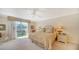 Bright bedroom showcasing large windows with lush views, a ceiling fan, and neutral decor at 1212 Benjamin Franklin Dr # 503, Sarasota, FL 34236