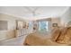 Comfortable bedroom featuring a ceiling fan, dresser with mirror, and lots of natural light at 1212 Benjamin Franklin Dr # 503, Sarasota, FL 34236