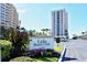 Exterior of the Lido Beach Club featuring a sign, lush landscaping, and a well-maintained parking area at 1212 Benjamin Franklin Dr # 503, Sarasota, FL 34236