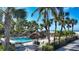 Community pool area with lounge chairs, tiki huts, and lush tropical landscaping at 1212 Benjamin Franklin Dr # 503, Sarasota, FL 34236