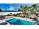Community pool area with tiki huts, lounge chairs, lush tropical landscaping, and beach access at 1212 Benjamin Franklin Dr # 503, Sarasota, FL 34236