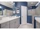 Stylish bathroom featuring a double vanity, blue walls, and a frameless glass shower enclosure at 12706 Cobalt Ter, Bradenton, FL 34211