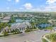 Aerial view of a lakefront community clubhouse with a pool and tennis courts at 12706 Cobalt Ter, Bradenton, FL 34211