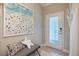 A stylish foyer featuring modern decor, including a beach-themed art piece and a sleek bench near the patterned front door at 12706 Cobalt Ter, Bradenton, FL 34211