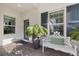 Charming front porch featuring a decorative bench, potted plants, windows with blue shutters and brick pavers at 12706 Cobalt Ter, Bradenton, FL 34211