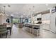 Bright, open-concept kitchen with white cabinets, a center island with seating, and views into the adjacent living space at 12706 Cobalt Ter, Bradenton, FL 34211