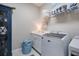 Well-lit laundry room featuring a front load washer and decorative shelving at 12706 Cobalt Ter, Bradenton, FL 34211