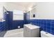 Bathroom with blue tiles, tub, vanity, and window providing natural light at 1401 Francis Ave, Sarasota, FL 34232