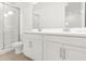 Bright bathroom featuring a double sink vanity with white cabinets and a glass-enclosed shower at 15001 Shady Palms Ln, Nokomis, FL 34275