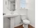 Bathroom featuring a pedestal sink, oval mirror, and white wooden floors at 15001 Shady Palms Ln, Nokomis, FL 34275