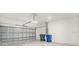 Spacious garage with roll-up metal door, concrete floor, and overhead lighting at 15001 Shady Palms Ln, Nokomis, FL 34275