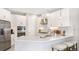 Bright kitchen features stainless steel appliances, white cabinetry, quartz countertops, and pendant lighting at 15001 Shady Palms Ln, Nokomis, FL 34275