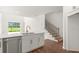 Well-lit kitchen featuring white cabinets, stainless steel dishwasher and sink, and view to a grassy yard at 15001 Shady Palms Ln, Nokomis, FL 34275