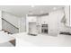 Stylish open-concept kitchen featuring white cabinetry, stainless steel appliances, a central island, and a modern faucet at 15001 Shady Palms Ln, Nokomis, FL 34275