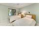 Cozy bedroom with two twin beds, ceiling fan, and natural light from the window at 1617 Bayhouse Ct # 121, Sarasota, FL 34231