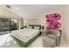 Bright bedroom with a sliding door, plush bed, stylish chair, and vibrant artwork at 1617 Bayhouse Ct # 121, Sarasota, FL 34231