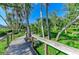 Inviting boardwalk with a built-in bench that meanders through a tranquil landscape of trees and greenery at 1617 Bayhouse Ct # 121, Sarasota, FL 34231