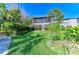Serene two-story home with a lush green lawn, mature landscaping, and a screened balcony at 1617 Bayhouse Ct # 121, Sarasota, FL 34231