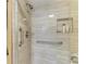 Close-up of a tiled shower with a grab bar, shower niche, and modern fixtures at 1617 Bayhouse Ct # 121, Sarasota, FL 34231