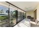 Spacious sunroom featuring tiled floors, ceiling fan and panoramic views of the lush landscape and waterfront at 1617 Bayhouse Ct # 121, Sarasota, FL 34231