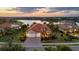 Beautiful aerial view of the home by the lake with lush landscaping and a tile roof at 16309 Castle Park Ter, Lakewood Ranch, FL 34202