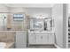 Elegant bathroom featuring dual vanity, quartz countertop, glass shower, and spacious walk-in closet at 16309 Castle Park Ter, Lakewood Ranch, FL 34202