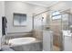 Modern bathroom showcasing tub with tile surround and seamless glass shower with window at 16309 Castle Park Ter, Lakewood Ranch, FL 34202