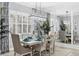 Dining room with an elegant light fixture, seating for six, shuttered windows, and interior plants at 16309 Castle Park Ter, Lakewood Ranch, FL 34202