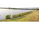 Scenic lake view with grassy shoreline, showcasing waterfront living and natural beauty at 16309 Castle Park Ter, Lakewood Ranch, FL 34202