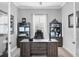Home office with dark wood furnishings, shutters on windows, and decorative shelving at 16309 Castle Park Ter, Lakewood Ranch, FL 34202