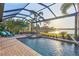 Relaxing pool with a spillover spa, tanning chairs, and lake views from the screened patio at 16309 Castle Park Ter, Lakewood Ranch, FL 34202