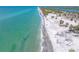 Stunning aerial view of a white sand beach, turquoise waters, and lush green vegetation at 1680 Lemon Bay Dr, Venice, FL 34293