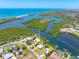 Expansive aerial shot showcasing the home's prime waterfront location with lush greenery and sparkling waters at 1680 Lemon Bay Dr, Venice, FL 34293