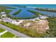 Aerial view of a parking area near a waterway, with beach access, greenery, and blue skies at 1680 Lemon Bay Dr, Venice, FL 34293
