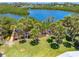 Beautiful aerial of a waterfront home with lush palm trees, new dock and kayak access to a scenic lagoon at 1680 Lemon Bay Dr, Venice, FL 34293
