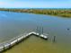 Picturesque dock on calm waters, surrounded by lush vegetation, offering a serene waterfront setting at 1680 Lemon Bay Dr, Venice, FL 34293
