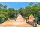 Relaxing on a wooden dock, featuring lush greenery, serene water, and a comfortable chair to enjoy the waterfront at 1680 Lemon Bay Dr, Venice, FL 34293
