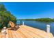 A wooden chair sits on a new dock with lovely views of a lagoon surrounded by mangroves at 1680 Lemon Bay Dr, Venice, FL 34293