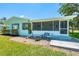 Well-maintained home featuring a cozy screened-in porch, lush landscaping, and a charming outdoor sitting area at 1680 Lemon Bay Dr, Venice, FL 34293